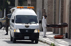 Forensic workers remove one of three bodies slain at an abandoned warehouse in the suburb of Guadalupe in Monterrey, northern Mexico, April 8, 2009.